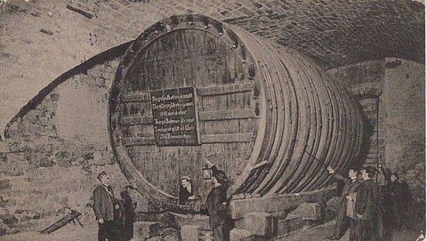 Schwarz-Weiß-Aufnahme des aufgebockten Fasses im Schlosskeller mit Menschen darum herum (Tübingen um 1915)