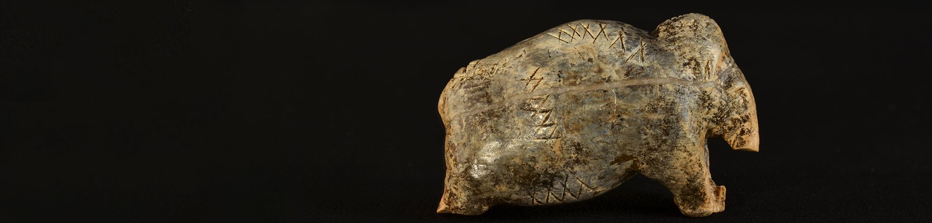 Foto: MUT | Juraj Liptak Nach rechts gewandte Mammutfigurine aus Mammutelfenbein mit rudimentar erhaltenen Gliedmaßen und Rüssel