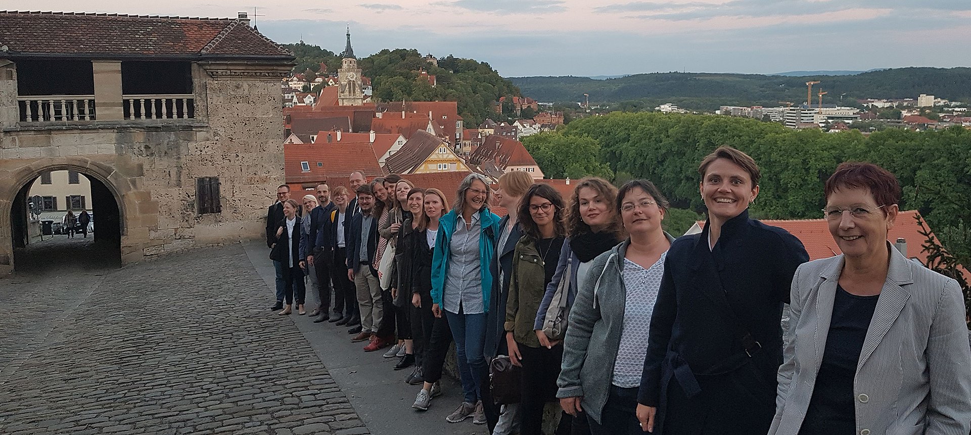 Photo: MUT The workshop participants stand next to each other on the wall of the entrance to Hohentübingen Palace; the Lower Castle Gate is in the background