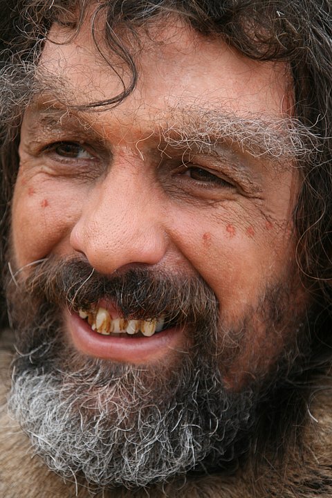 Rudolf Walter in Maske, mit aufgetragener Braue und Zahnprothese, als Neandertaler
