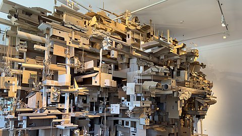Zu sehen ist ein großes Gebilde aus Papierobjekten, hergestellt von Besuchenden, die zu einem großen zusammgengefügt wurden, in der Kinderbiennale „PLANET UTOPIA" 