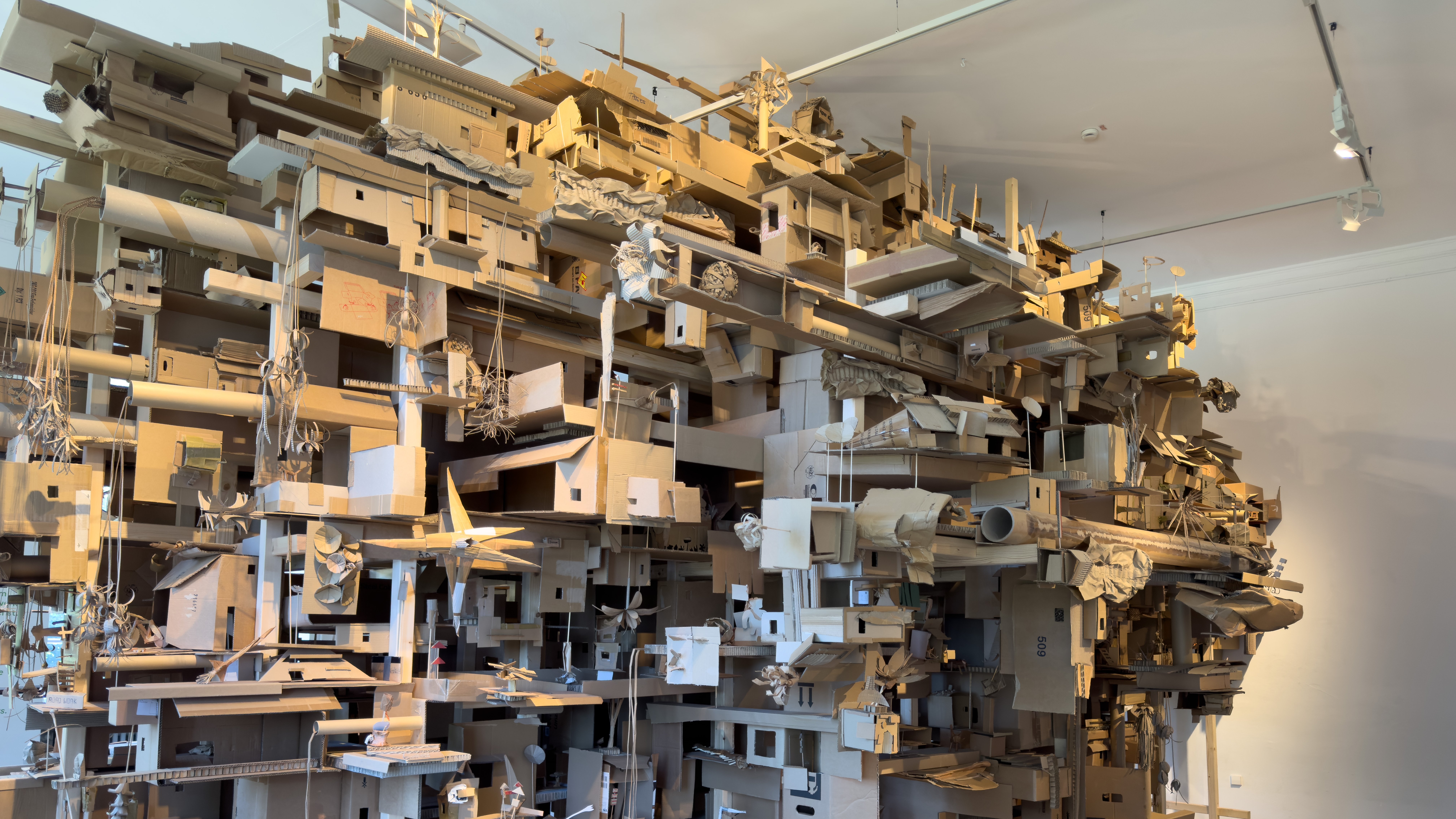 Zu sehen ist ein großes Gebilde aus Papierobjekten, hergestellt von Besuchenden, die zu einem großen zusammgengefügt wurden, in der Kinderbiennale „PLANET UTOPIA" 