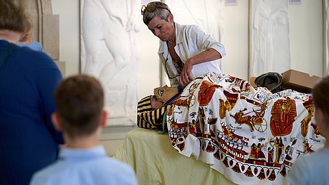 © MUT | Fabian Kurze Dr. Ulrike Fritz wickelt einen unserer Mitarbeiter aus, den sie zuvor in Bandagen eingewickelt hat.