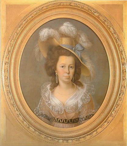 Ovales Porträt einer Frau in einem feinen Kleid des 18. Jahrhunderts mit Spitzenbesatz und Perlenkette. Sie trägt eine große, mit Federn und einer blauen Schleife geschmückte Strohhut. Der Hintergrund ist neutral gehalten, und das Bild ist in einem reich verzierten, goldfarbenen Rahmen gefasst.