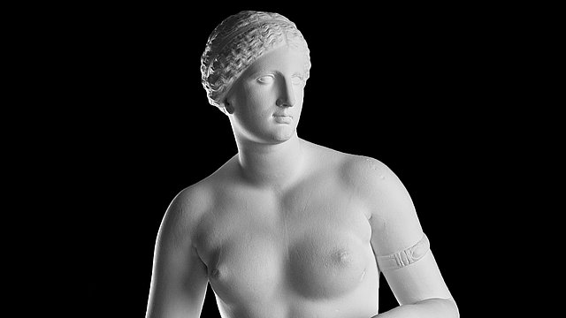 Foto: MUT | Valentin Marquardt Büsten-Ausschnitt einer weißen Statue einer unbekleideten Aphrodite mit nach rechts geneigtem Kopf und einem Reifen an ihrem linken Arm