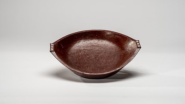 Tilted oval, wooden bowl with its small sides tapering to handles