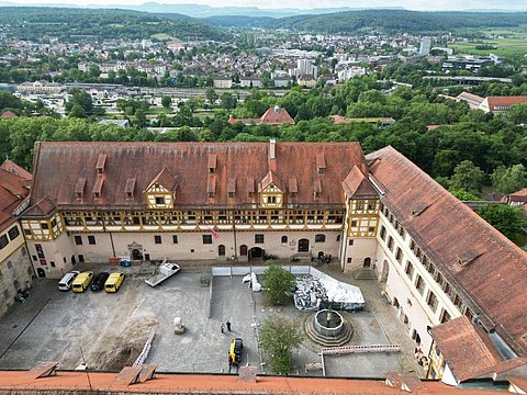 © Hermann Paule GmbH & Co. KG | H. Singer Zu sehen ist eine Luftansicht vom Schlosshof mit Material zum Ausbau der Fernwärmeleitung