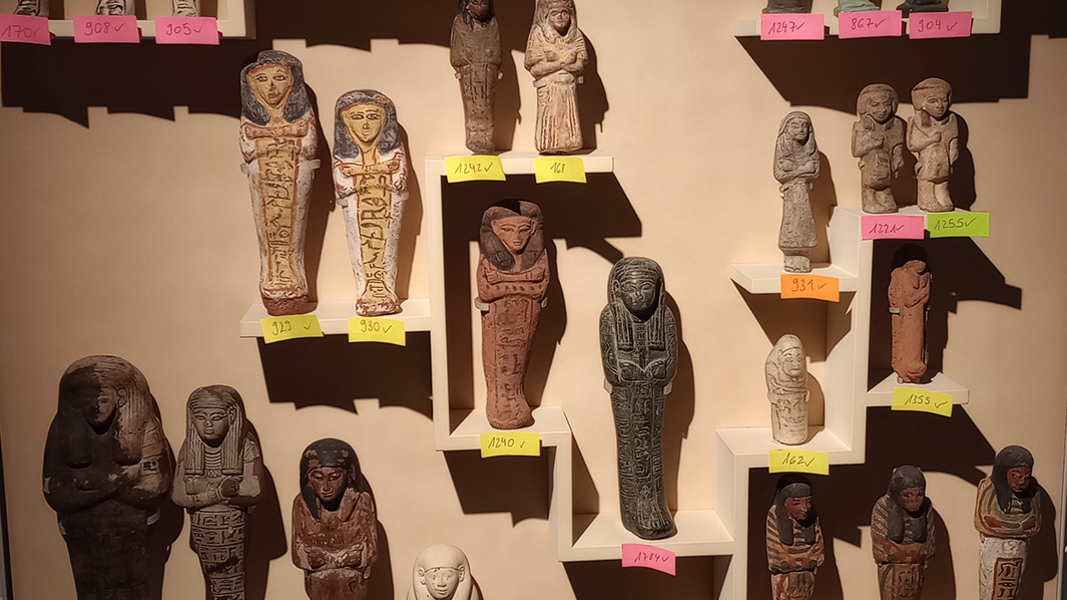 Uschebti in der Vitrine der Ägyptologischen Sammlung im Museum Alte Kulturen; bunte Post-it-Zettel markieren die einzelnen Statuen mit ihren Inventarnummern