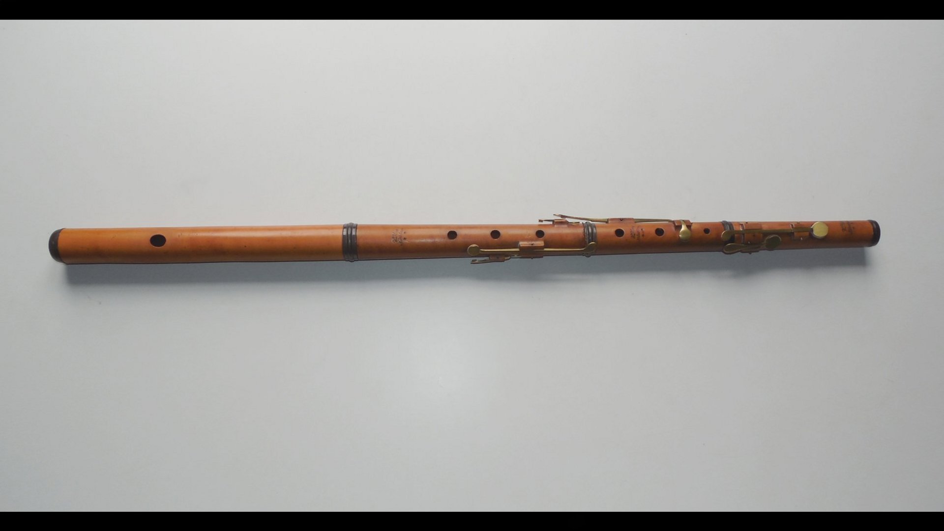langes Holzblasinstrument auf grauem Untergrund