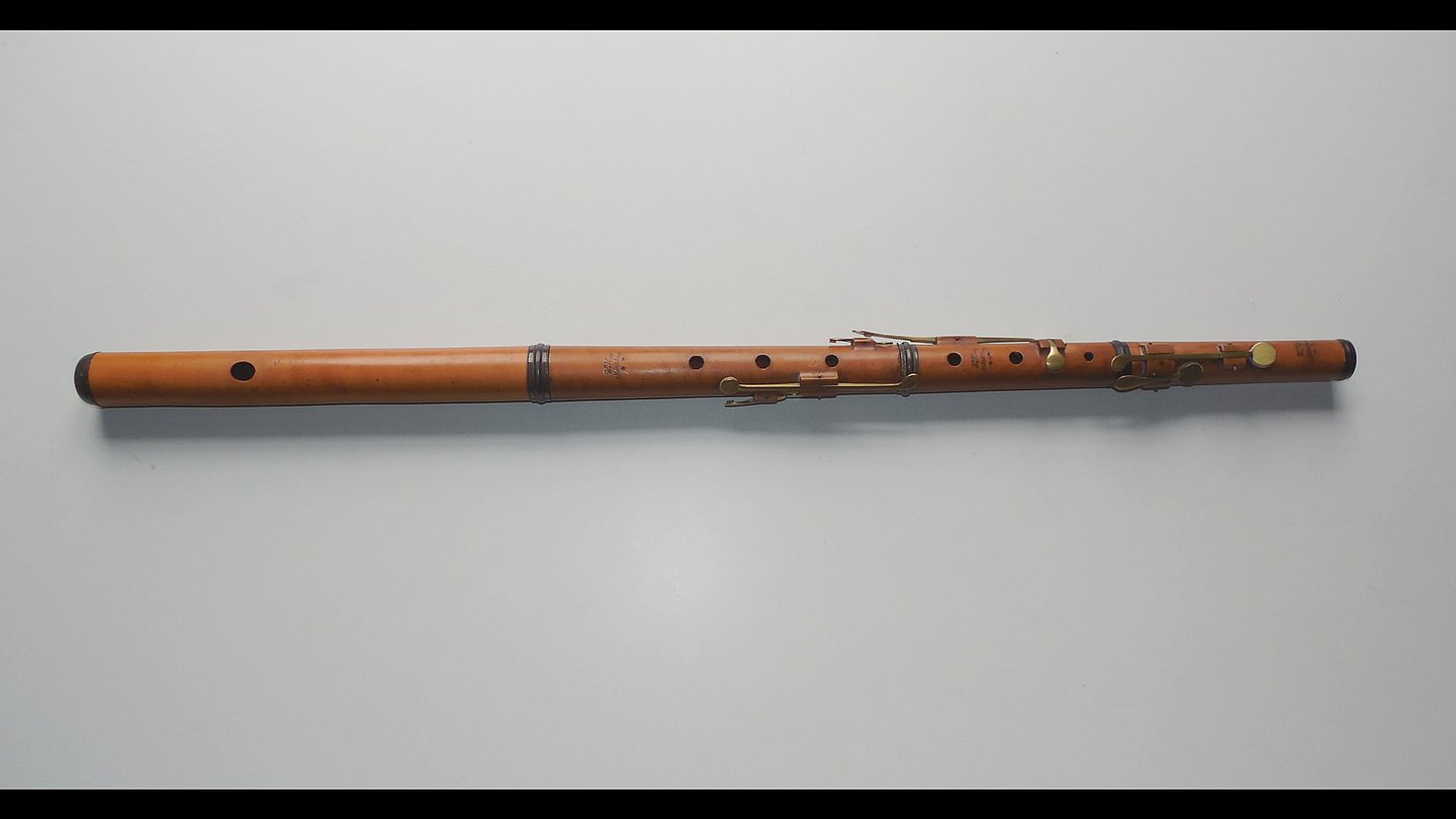 langes Holzblasinstrument auf grauem Untergrund
