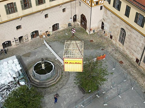 © Hermann Paule GmbH & Co. KG | H. Singer Zu sehen ist eine Luftansicht vom Schlosshof mit Material zum Ausbau der Fernwärmeleitung