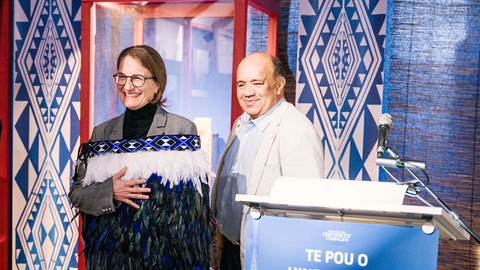 Prodekanin Monique Scheer (links) im Federmantel (korowai), dem Geschenk der Delegation der Te Aitanga-a-Hauiti, vertreten durch Victor Walker (rechts) neben dem Rednerpult