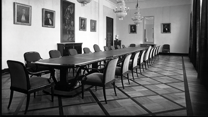 Historisches Schwarz-Weiß-Foto des Kleinen Senats der Universität Tübingen mit in Schwarz/Grau nach links verlängerter Fluchtlinie