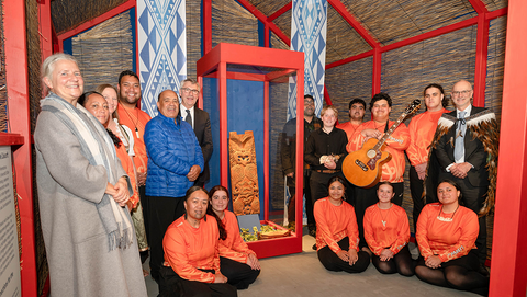 Im abstrakten Versammlungshaus des Ausstellungsaufbaus haben sich (v.l.n.r.) Universitätsrektorin Professorin Dr. Dr. h.c. (Doshisha) Karla Pollmann, Vertreter*innen der Te Aitanga-a-Hauiti, unter anderem der Vorsitzende des Te Aitanga-a-Hauiti Centre of Excellence Trust Victor Walker, Museumsdirektor Professor Dr. Ernst Seidl und Botschafter Craig John Hawke um die Vitrine mit Hinematioros Pou versammelt
