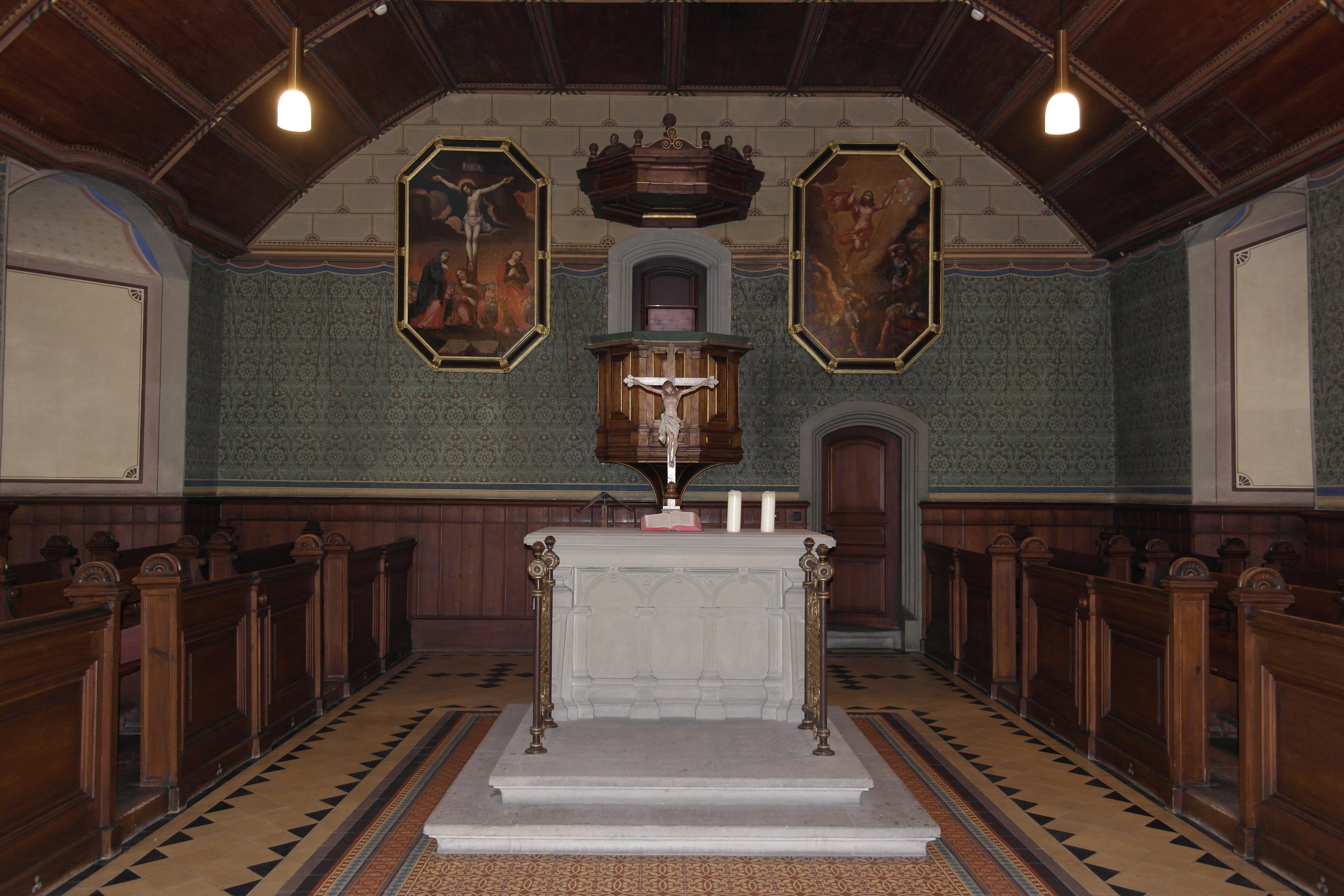 Frontalansicht des Altarbereichs der Schlosskirche mit weißem Altar mit hinaufführenden Stufen, Altargerät und im Hintergrund die Kanzel, flankiert von je einem Gemälde links (Kreuzigung Jesu) und rechts (Himmelfahrt Jesu)