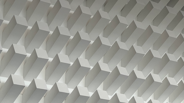 Großflächiges Betonrelief aus schräg nach oben aus der Wand ragenden Betonpfeilern, rasterartig angeordnet, im Foyer des Hörsaalzentrums der Universität Tübingen auf der Morgenstelle