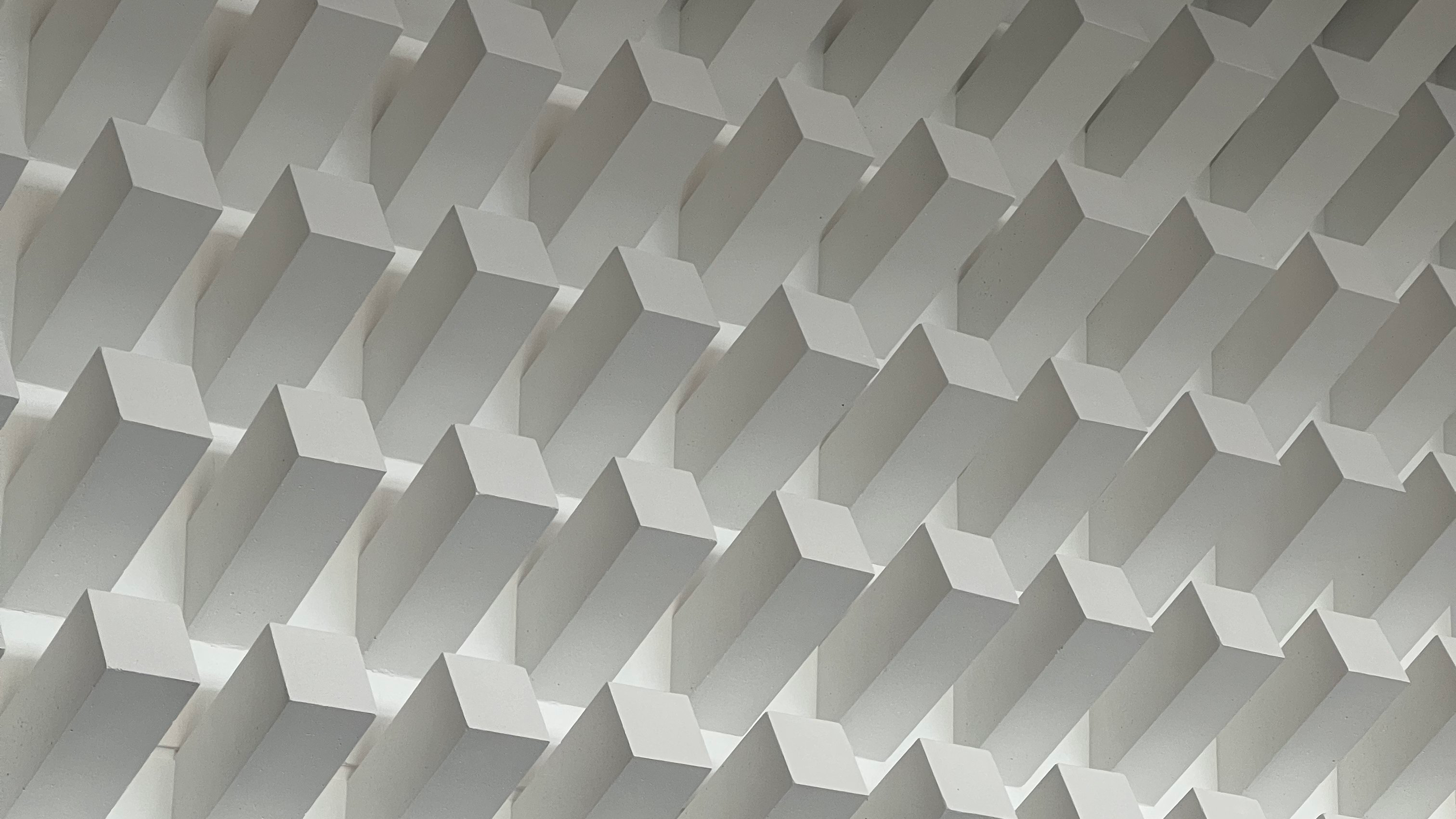 Großflächiges Betonrelief aus schräg nach oben aus der Wand ragenden Betonpfeilern, rasterartig angeordnet, im Foyer des Hörsaalzentrums der Universität Tübingen auf der Morgenstelle