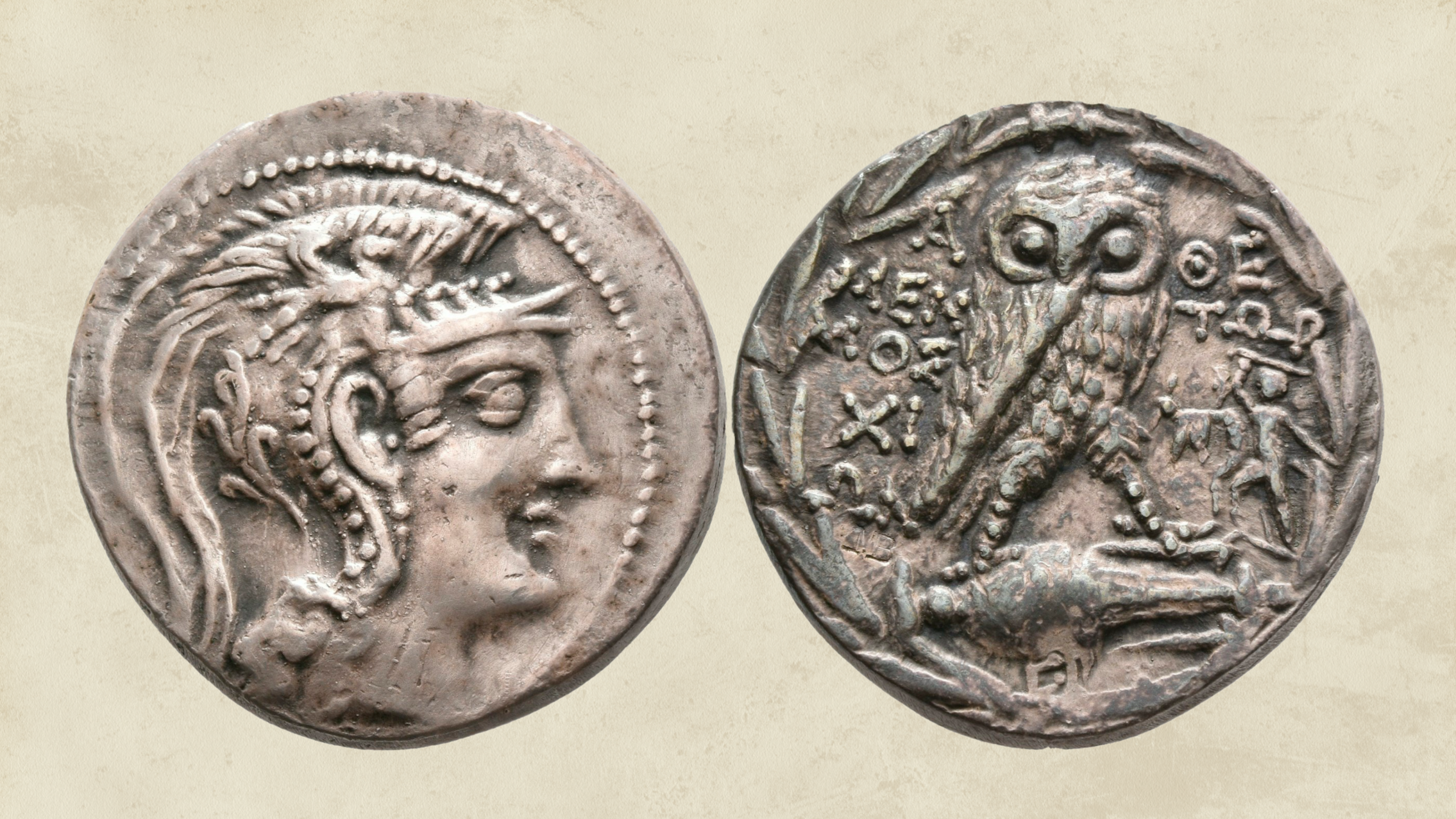 Moderne Reproduktion einer athenischen Silbermünze. Der Avers (links) zeigt den nach rechts gewandten Kopf der Athena Parthenos mit einem Helm mit Federbusch und Pferdedarstellungen, der Revers (rechts) zeigt eine nach rechts schreitende Eule über einer liegenden Amphore und rechts der Eule ist stilisiert die Statuengruppe der Tyrannenmörder abgebildet