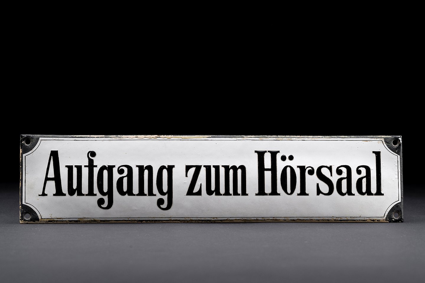 Small sign with holes in the corners for mounting on the wall