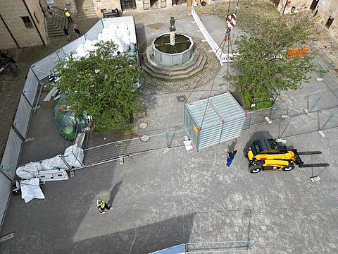 © Hermann Paule GmbH & Co. KG | H. Singer Zu sehen ist eine Luftansicht vom Schlosshof mit Material zum Ausbau der Fernwärmeleitung