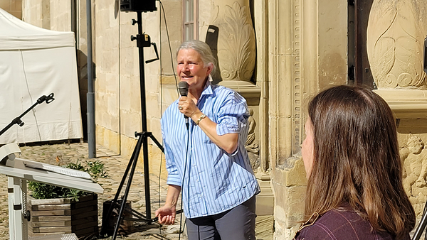 Universitätsrektorin Professorin Dr. Dr. h.c. (Doshisha) Karla Pollmann mit einem Handmikrophon vor dem Eingang zum Rittersaal im Innenhof von Schloss Hohentübingen