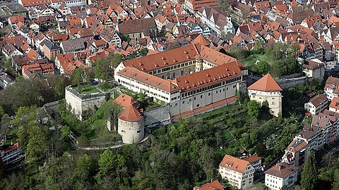 © MUT | Valentin Marquardt Aereal view of Hohentübingen Castle with greenery over the Castle Hill and the red roofs of Tübingen in the background