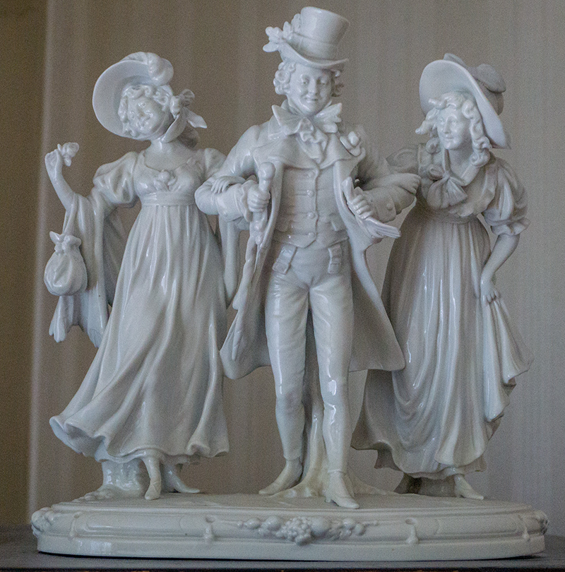 Foto: MUT | Lucas Rau Weiße Porzellanstatuette im Biedermeier-Stil, ein Herr mit einer Dame an jedem Arm