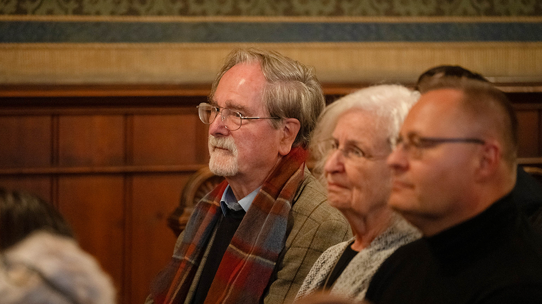 Auf einer der Kirchenbänke sitzt Dr. Volker Harms, Kustos der Ethnologischen Sammlung a.D.