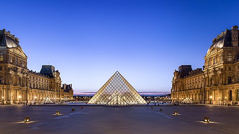 Blick nach Westen auf den Napoleonhof des Louvre mit Pyramide in der Abenddämmerung