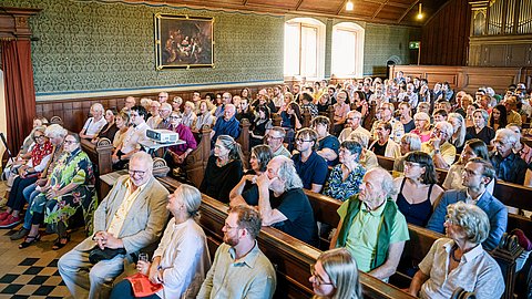 Schräger Blickwinkel auf die voll besetzte Schlosskirche auf Schloss Hohentübingen