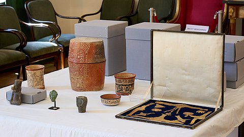 © MUT | F. Kurze Zu sehen ist eine Nahaufnahme einiger Objekte des Nachlasses wie Goldschmuck oder eine kleine Jadefigur