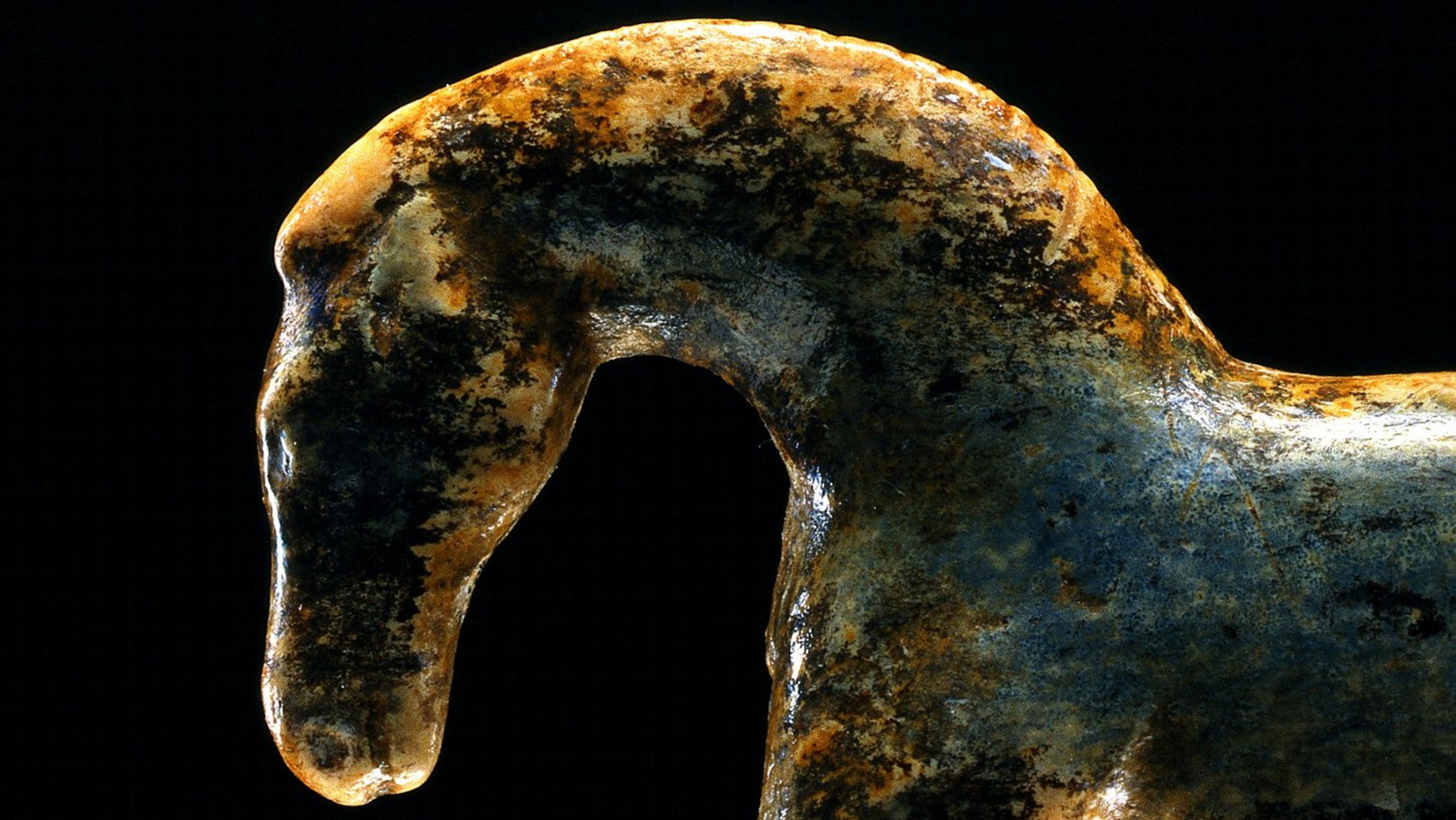 Mammoth ivory figurine of a horse, turned to the left with curved neck; the legs are only preserved rudimentarily