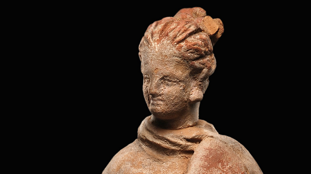 Gewandstatuette aus Terrakotta, eine Frau mit nach rechts geneigtem Kinn und vor der Brust gehaltenem Fächer