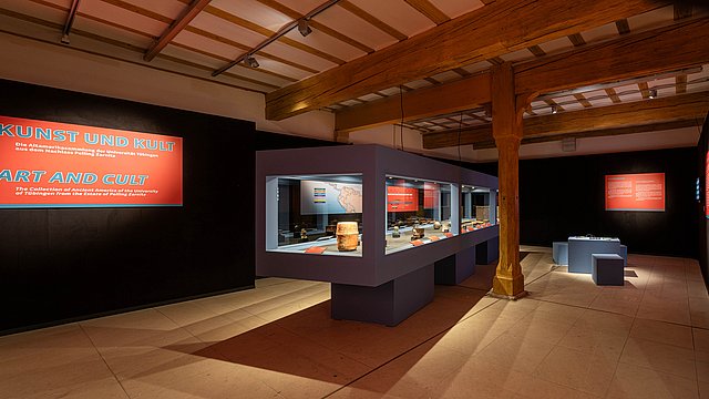 © MUT | Valentin Marquardt Panorama view of the deserted exhibition with the central, Mayan-blue showcase and illuminated exhibition panels at the black walls