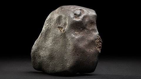 Foto: MUT | Valentin Marquardt Ein grauer Klumpen Meteorit vor dunklem Hintergrund