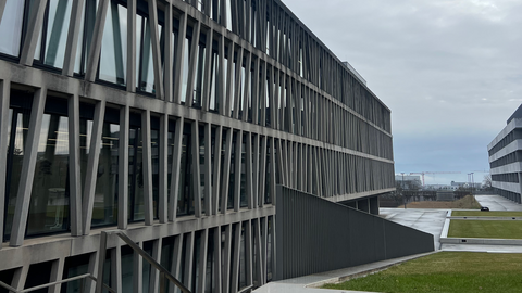 Schräge Ansicht einer Fassade mit sich gabelnden Betonstreben vor Glas auf der Morgenstelle