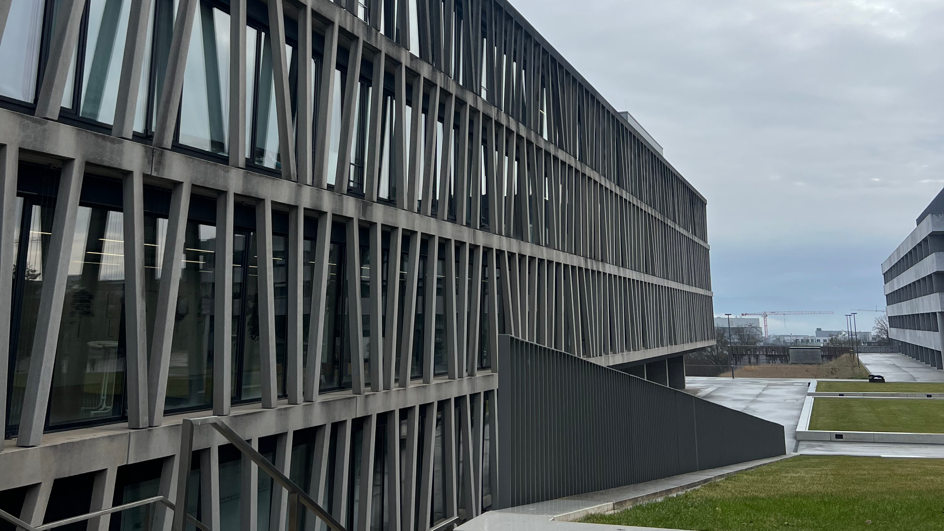 Schräge Ansicht einer Fassade mit sich gabelnden Betonstreben vor Glas auf der Morgenstelle