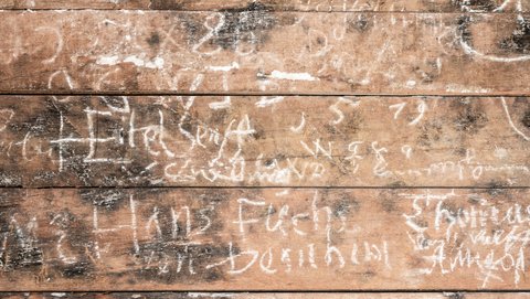 Holzbohlen der Innenwand, mit Kreide bekritzelt