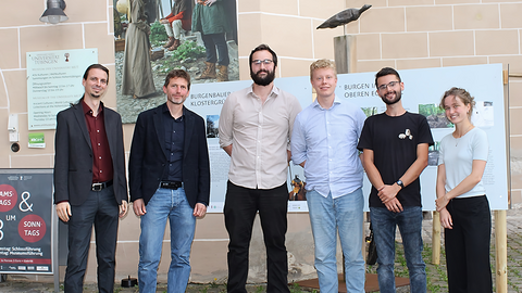 Foto: Gabriele Böhm Das Team der Burgenausstellung "Ausgegraben!" vor den Informationstafeln am Eingang zum MUT | Museum Alte Kulturen