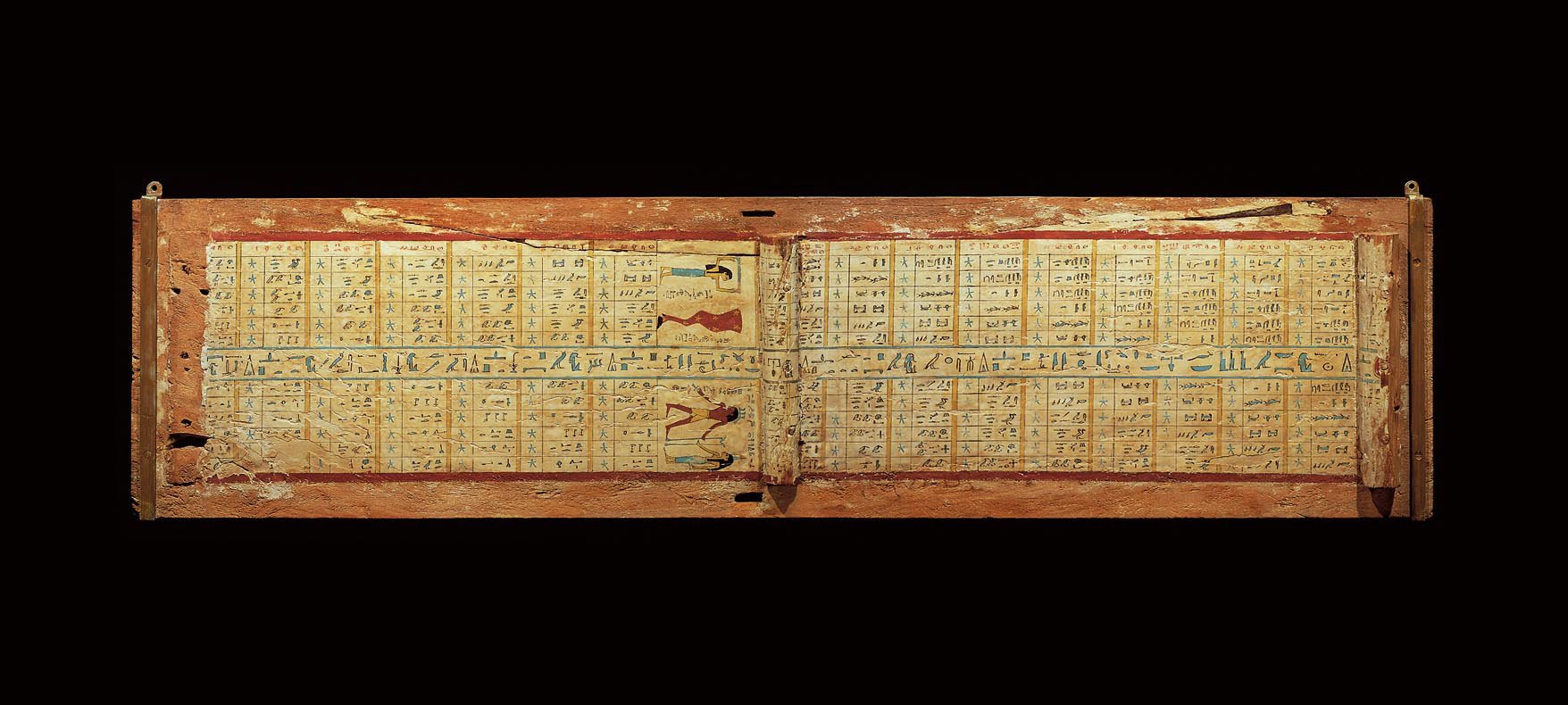 Mit hieroglyphischer Inschrift bedeckter Sargdeckel aus Holz vor schwarzem Hintergrund