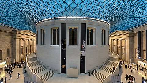 Foto: David Iliff | CC BY-SA 3.0 Atrium des British Museum in London mit zentralem Rundbau, an dem links und rechts je eine Treppe hinaufführt